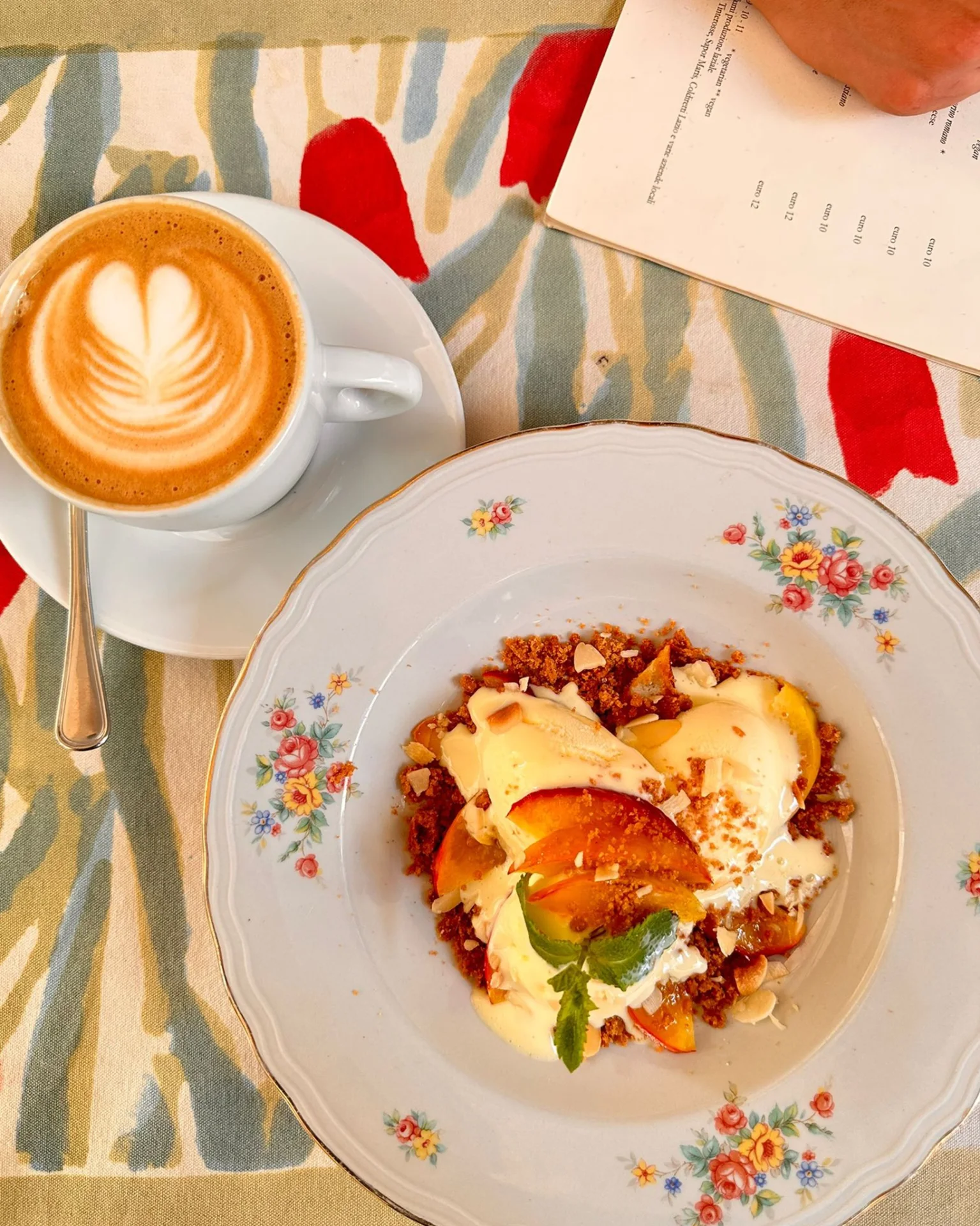 Cappuccino mit Latte Art und Dessert mit Pfirsichen und Sahne – Frühstück im Caffè Novecento Roma